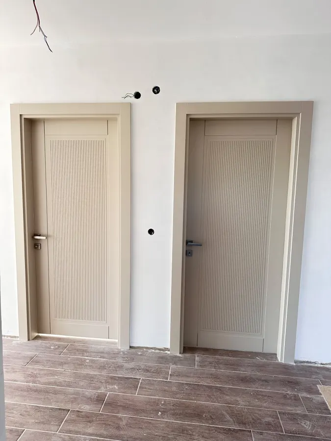 Modern beige lacquered interior door with routed grooves