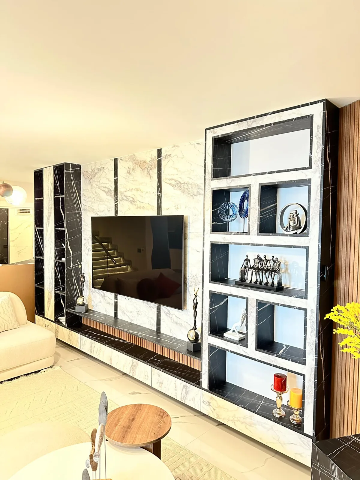 TV unit with black and white marble panels and LED niches