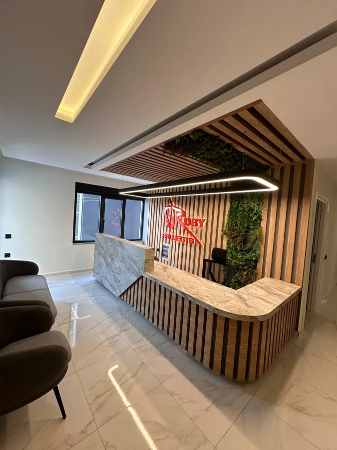 Office reception desk with oak slats and a moss wall